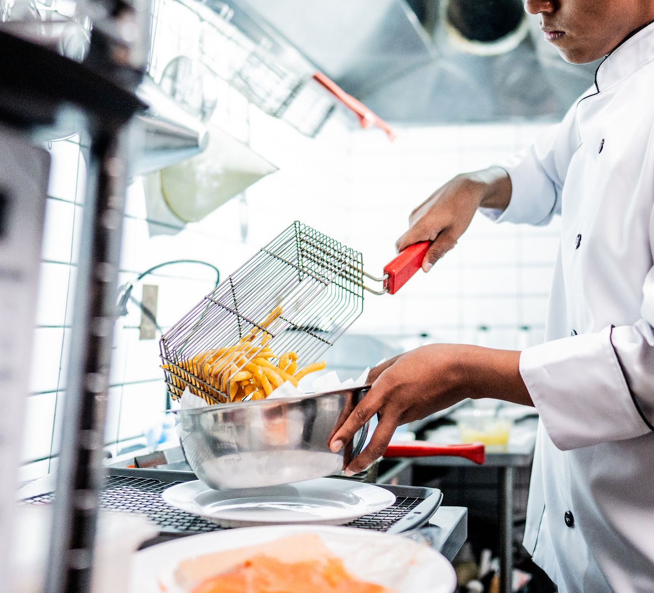 Chef working in a commercial kitchen fryer station